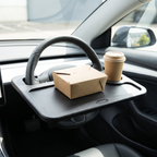 Steering wheel desk holding a takeaway box and drink in a parked car